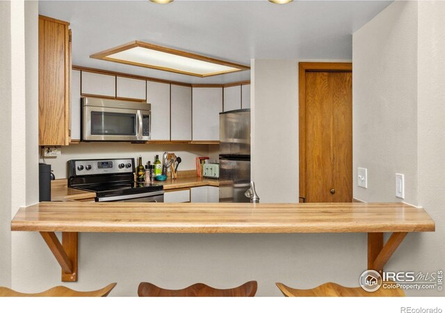2962 Shadow Creek Dr # 308, Boulder, CO 80303 - kitchen featuring stainless steel appliances, a kitchen bar, and light countertops