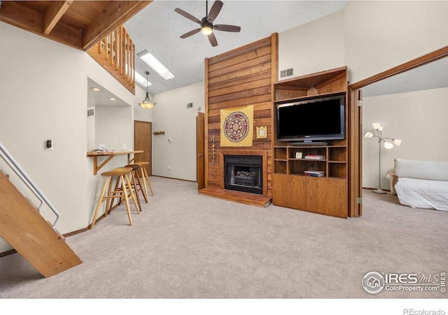 2962 Shadow Creek Dr # 308, Boulder, CO 80303 - carpeted living area featuring ceiling fan, a fireplace with raised hearth, high vaulted ceiling, a skylight, and beamed ceiling