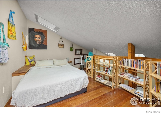 2962 Shadow Creek Dr # 308, Boulder, CO 80303 - bedroom with lofted ceiling, a textured ceiling, and wood finished floors