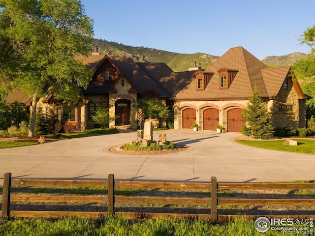 9840 Buckhorn Rd, Loveland, CO 80538 - view of front of house featuring stone siding, fence, curved driveway, and a chimney