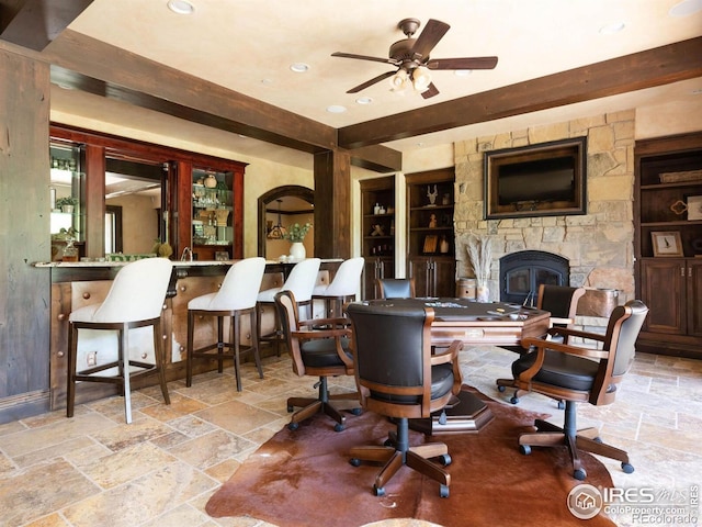 9840 Buckhorn Rd, Loveland, CO 80538 - living room with built in shelves, stone tile flooring, a ceiling fan, a stone fireplace, and recessed lighting