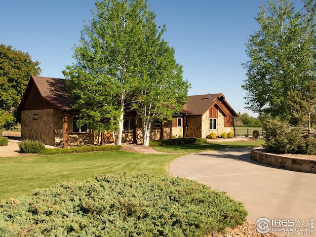 9840 Buckhorn Rd, Loveland, CO 80538 - view of front of home featuring stone siding, a front lawn, board and batten siding, and driveway