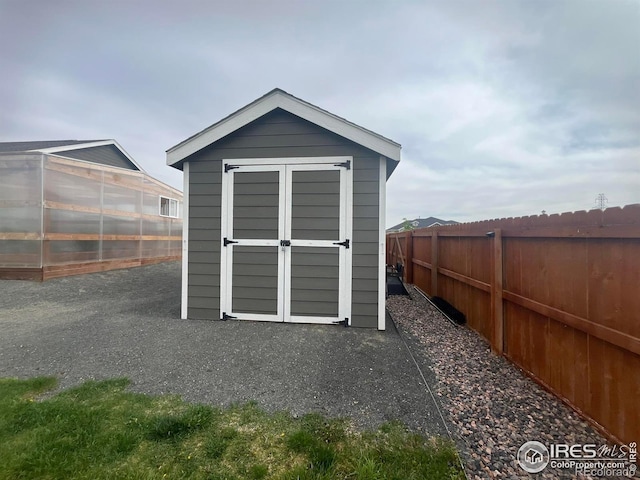view of greenhouse featuring a fenced backyard