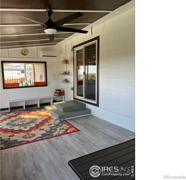 wooden deck with a ceiling fan and a wall mounted AC