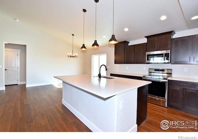 kitchen featuring stainless steel appliances, a sink, dark wood-style flooring, an island with sink, and light countertops
