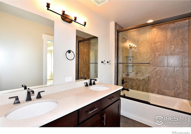 full bathroom featuring combined bath / shower with glass door and double vanity