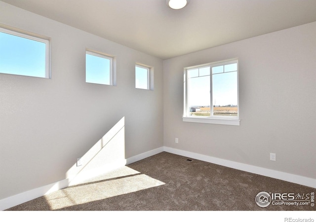 carpeted empty room with baseboards