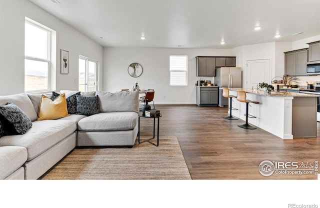 2727 73rd Ave, Greeley, CO 80634 - living room featuring healthy amount of natural light, dark wood-type flooring, recessed lighting, and baseboards