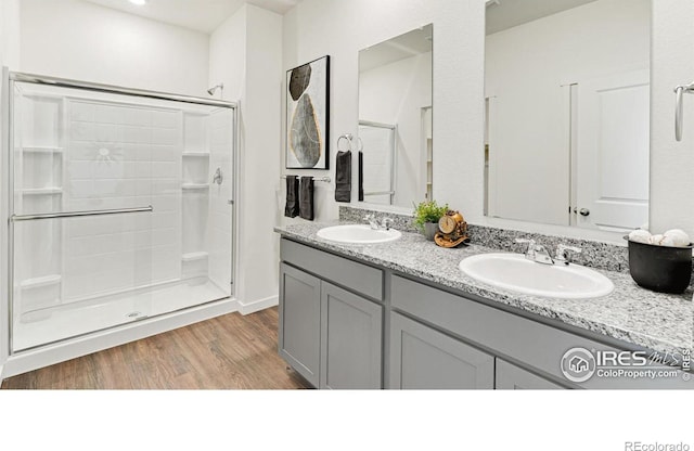 2727 73rd Ave, Greeley, CO 80634 - bathroom featuring a shower stall, wood finished floors, and double vanity
