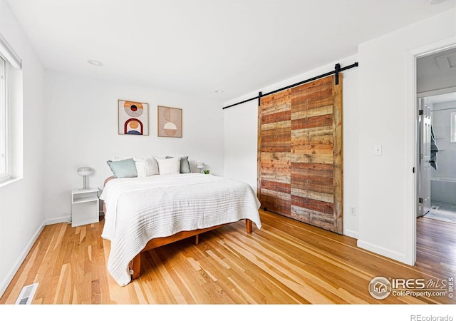 1350 Lehigh St, Boulder, CO 80305 - bedroom featuring a barn door, light wood-type flooring, and baseboards