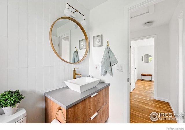 1350 Lehigh St, Boulder, CO 80305 - half bath with wood finished floors, vanity, toilet, and tile walls