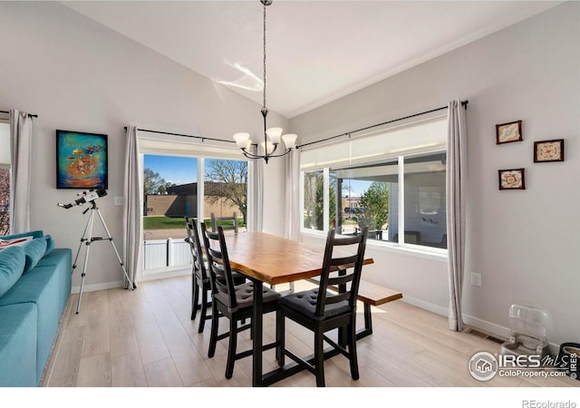 3593 Taylor Walker St, Loveland, CO 80537 - dining space with a chandelier, vaulted ceiling, light wood-style floors, and baseboards