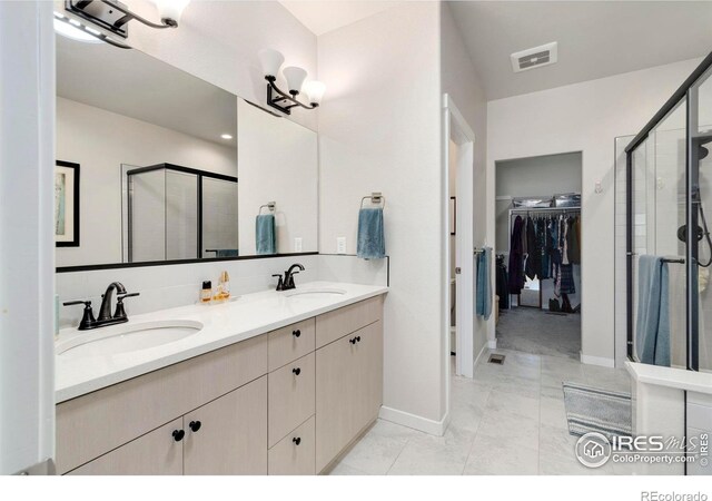 3593 Taylor Walker St, Loveland, CO 80537 - bathroom featuring a stall shower, baseboards, a walk in closet, and double vanity