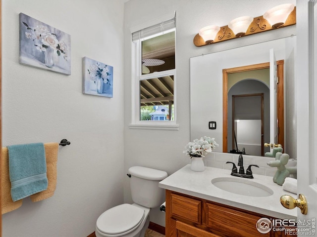 half bath featuring toilet and vanity