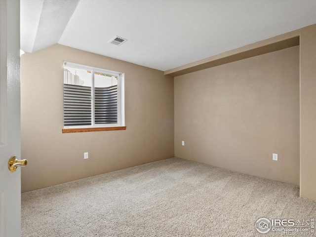 spare room with carpet flooring and lofted ceiling
