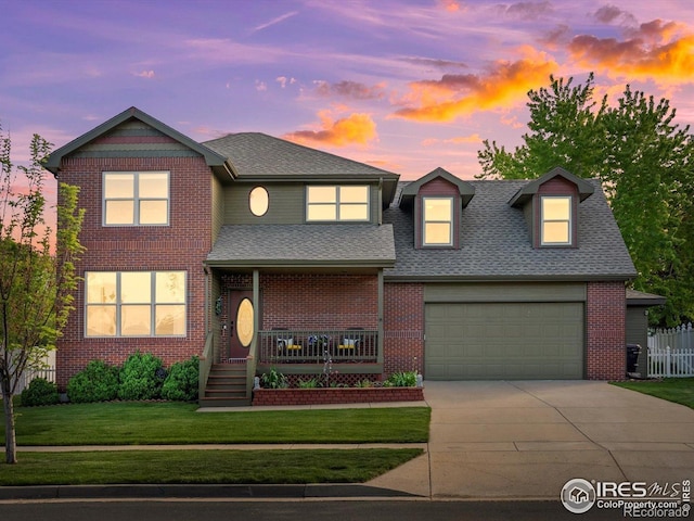 traditional-style home with concrete driveway, a lawn, roof with shingles, and brick siding