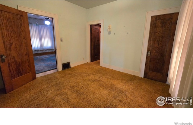 unfurnished bedroom with carpet floors and baseboards
