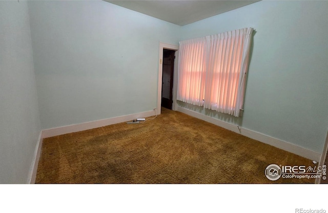 unfurnished room featuring carpet floors and baseboards
