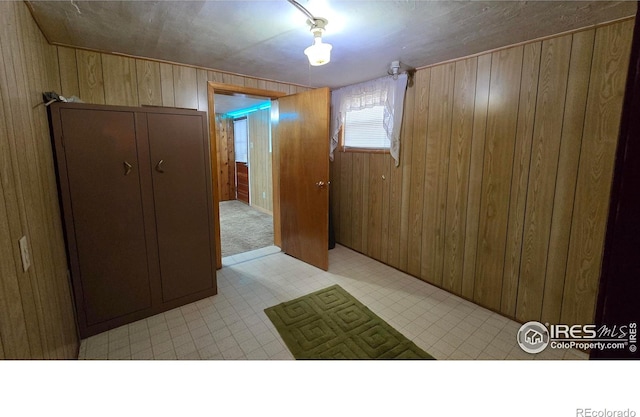 empty room featuring wooden walls and light floors