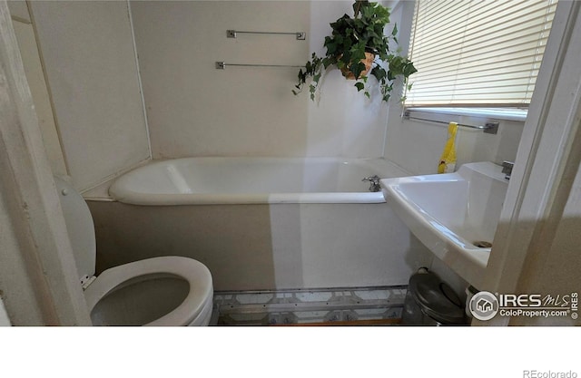 full bath with a tub to relax in, toilet, and tile patterned floors
