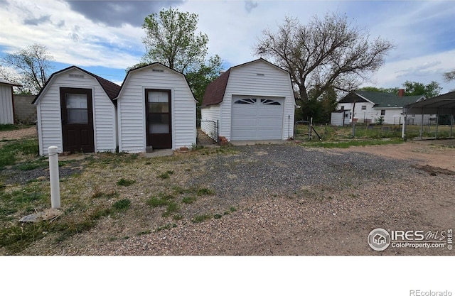 detached garage with a storage shed and fence