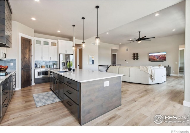 1721 Brightwater Dr, Fort Collins, CO 80524 - kitchen with stainless steel appliances, white cabinets, light wood-type flooring, a ceiling fan, and recessed lighting