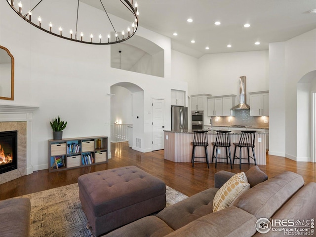 950 Sumner Way, Erie, CO 80516 - living area with arched walkways, a high ceiling, dark wood-style flooring, recessed lighting, and baseboards