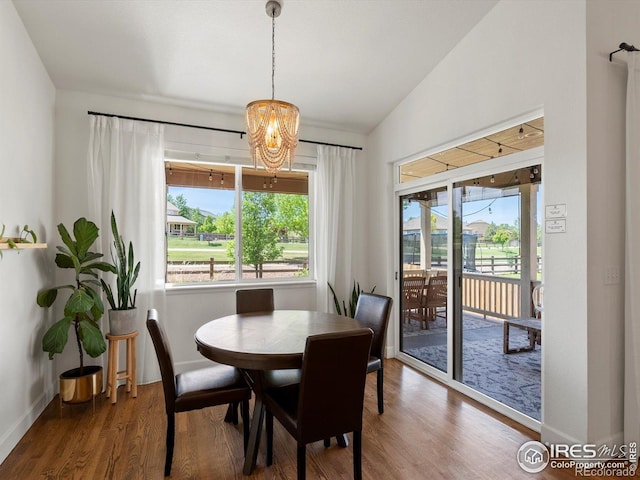 950 Sumner Way, Erie, CO 80516 - dining room featuring wood finished floors, a chandelier, baseboards, and vaulted ceiling