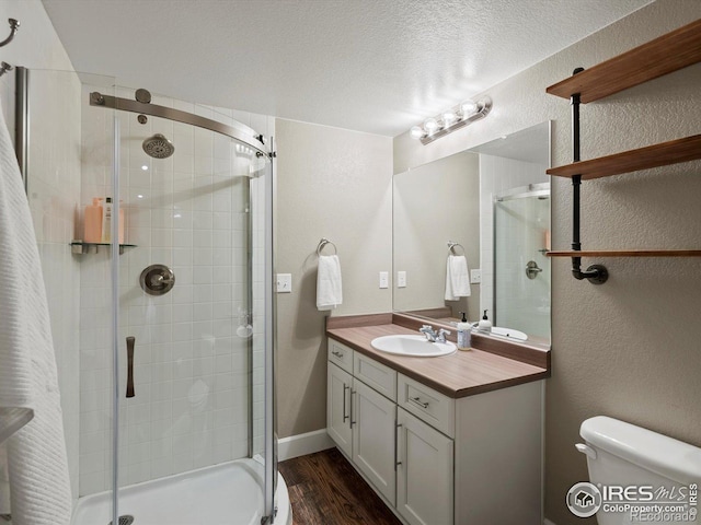 950 Sumner Way, Erie, CO 80516 - full bath with a stall shower, wood finished floors, toilet, vanity, and a textured ceiling