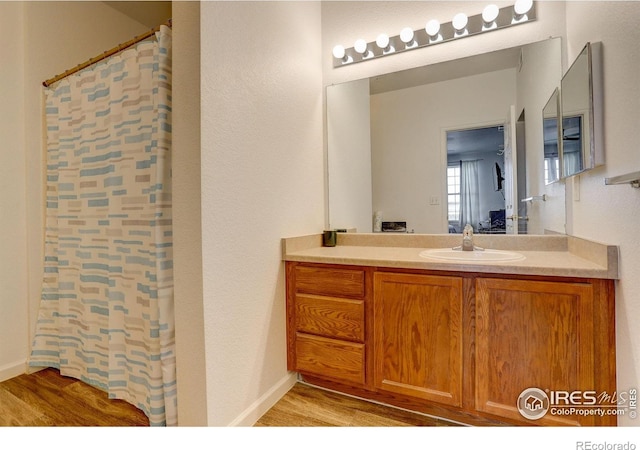 5723 N Gibralter Way Unit 205, Aurora, CO 80019 - bathroom featuring wood finished floors, vanity, and a shower with shower curtain