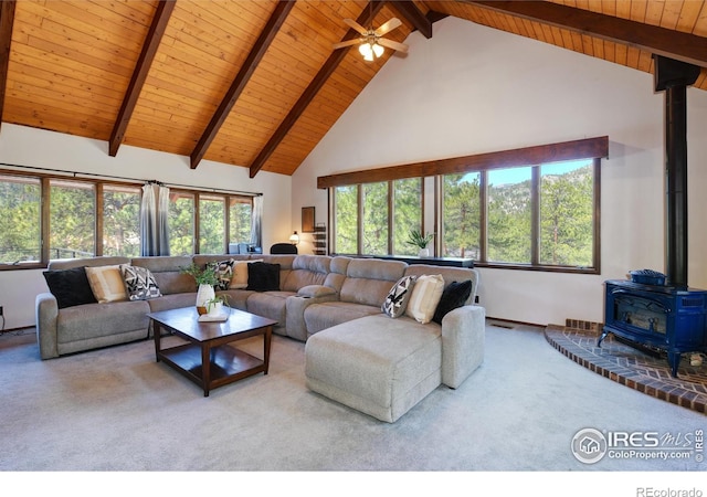 40 Hopi Ct, Lyons, CO 80540 - carpeted living room featuring a wood stove, high vaulted ceiling, wooden ceiling, beamed ceiling, and a ceiling fan