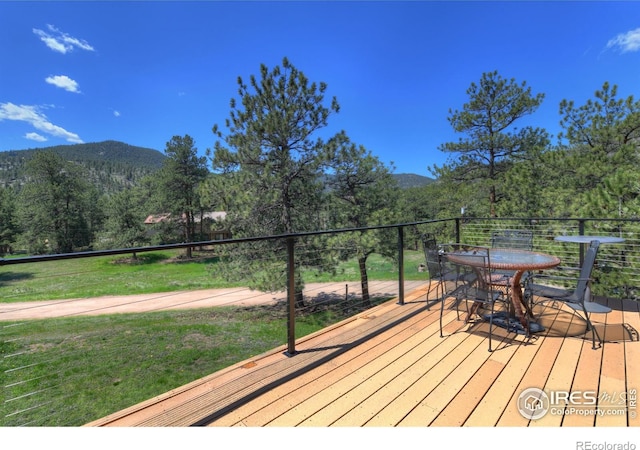 40 Hopi Ct, Lyons, CO 80540 - wooden terrace featuring a mountain view, outdoor dining space, a view of trees, and a yard