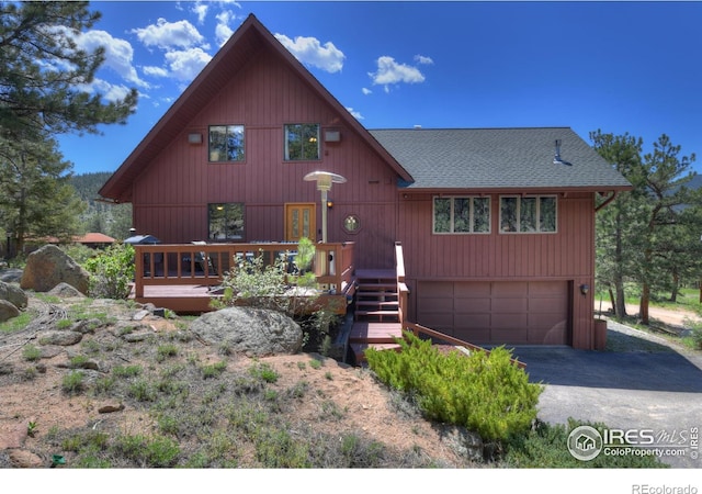 40 Hopi Ct, Lyons, CO 80540 - rustic home with an attached garage, roof with shingles, asphalt driveway, and a wooden deck