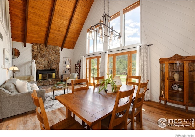 40 Hopi Ct, Lyons, CO 80540 - dining space with high vaulted ceiling, wood finished floors, wooden ceiling, a stone fireplace, and beamed ceiling