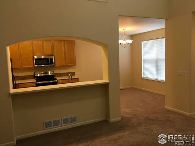 6608 W 3rd St Unit 35-58, Greeley, CO 80634 - kitchen featuring stainless steel appliances, dark carpet, arched walkways, a chandelier, and a sink