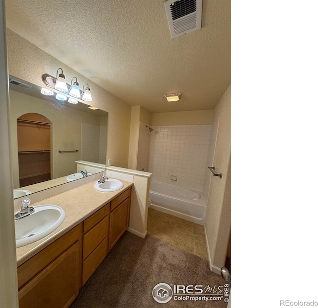 6608 W 3rd St Unit 35-58, Greeley, CO 80634 - bathroom featuring  shower combination, double vanity, and a textured ceiling