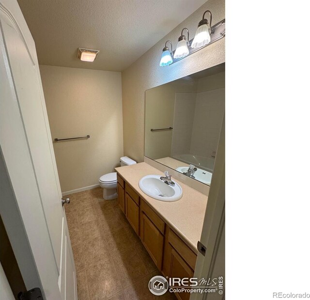 6608 W 3rd St Unit 35-58, Greeley, CO 80634 - bathroom with toilet, vanity, a textured ceiling, and tile patterned floors