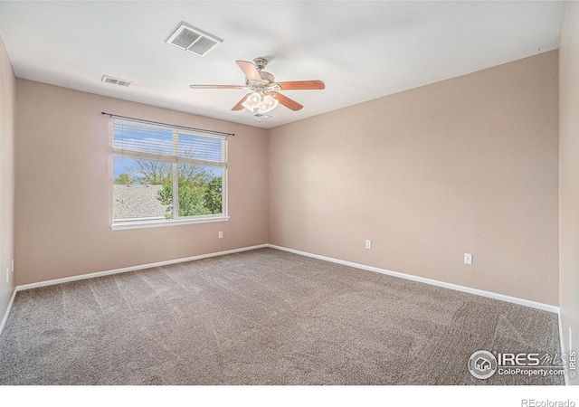 carpeted spare room featuring a ceiling fan and baseboards