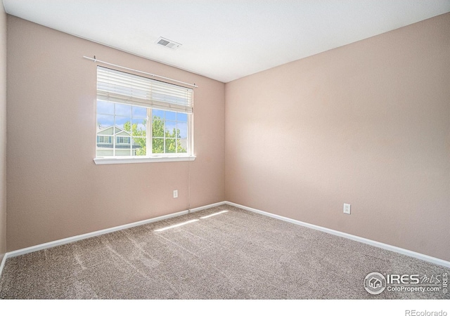carpeted empty room with baseboards