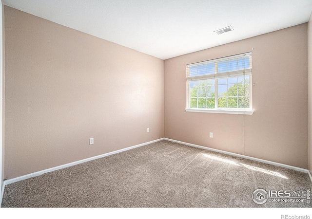 unfurnished room featuring carpet and baseboards