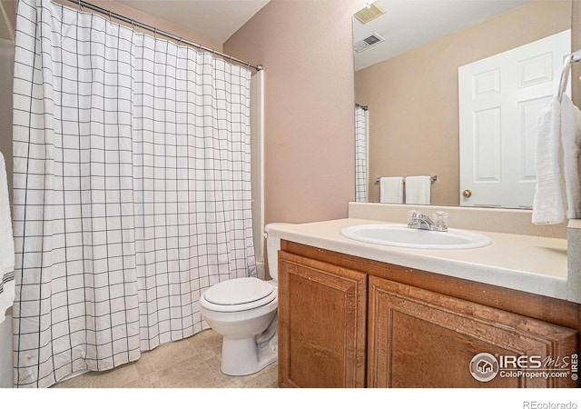 bathroom with vanity, toilet, curtained shower, and tile patterned floors