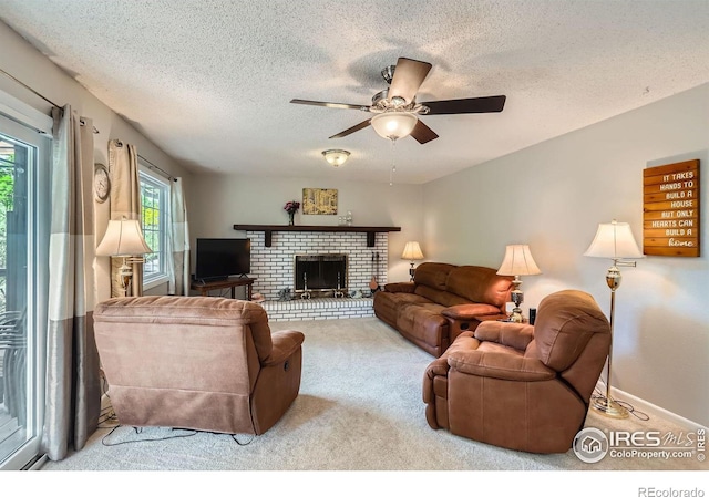 living room with carpet, ceiling fan, a textured ceiling, a fireplace, and baseboards