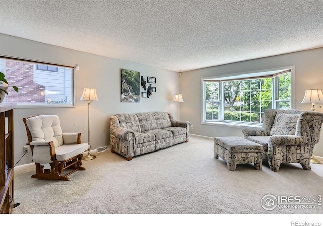 carpeted living room featuring a textured ceiling and baseboards