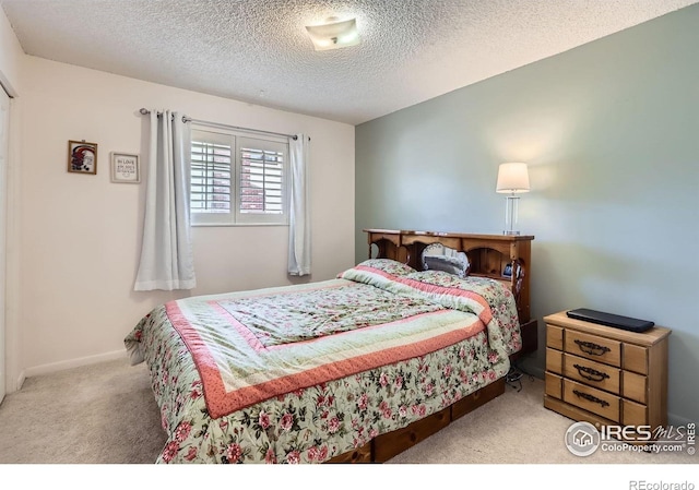 bedroom featuring carpet and a textured ceiling
