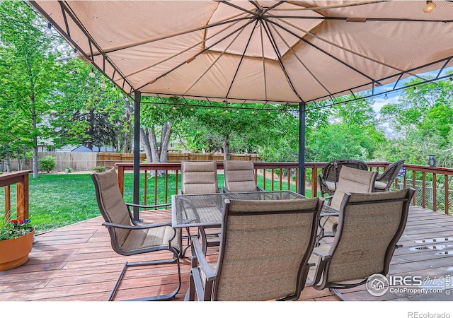 wooden terrace with outdoor dining space and a gazebo