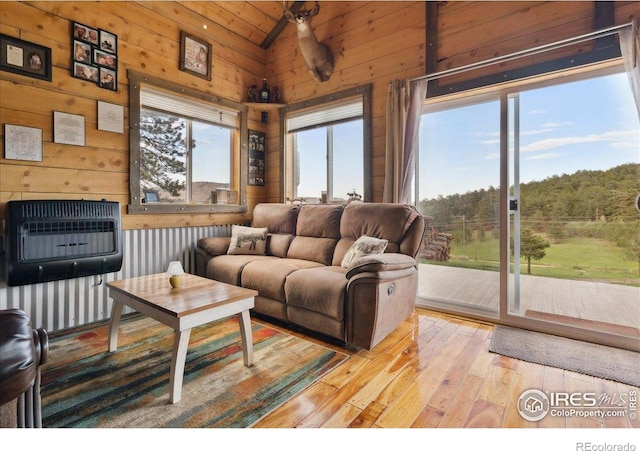 1095 Spruce Mountain Dr, Drake, CO 80515 - living room featuring heating unit, light wood-style floors, wooden walls, and lofted ceiling