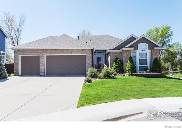 2409 Rock Creek Dr, Fort Collins, CO 80528 - view of front facade with an attached garage, concrete driveway, a front yard, brick siding, and roof with shingles