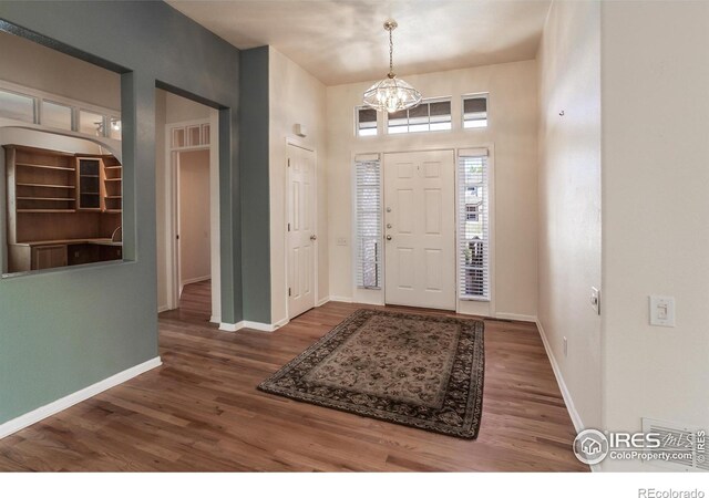 2409 Rock Creek Dr, Fort Collins, CO 80528 - foyer entrance with wood finished floors, a chandelier, and baseboards