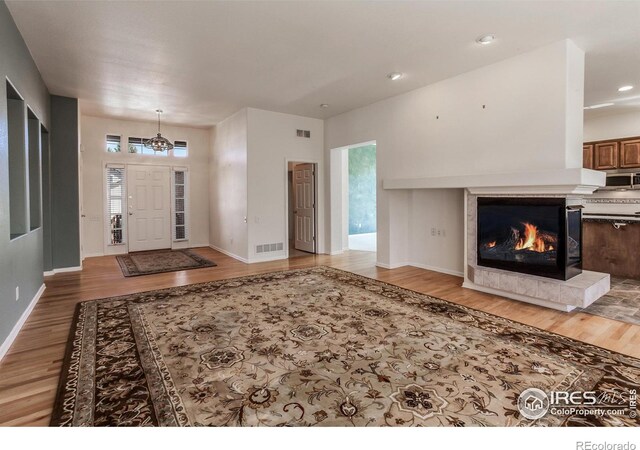 2409 Rock Creek Dr, Fort Collins, CO 80528 - entryway with light wood-style flooring, a chandelier, baseboards, a tile fireplace, and recessed lighting