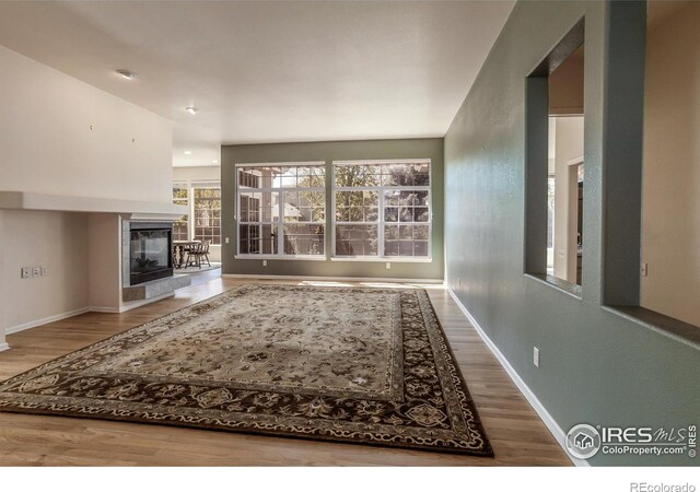 2409 Rock Creek Dr, Fort Collins, CO 80528 - unfurnished living room featuring wood finished floors, baseboards, and a fireplace